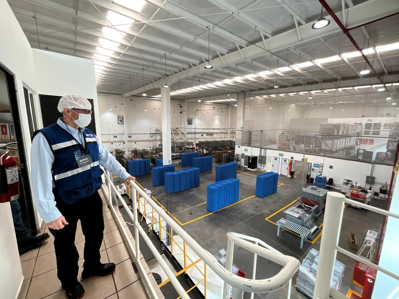 Supervisor de Maztec con equipo de protección observando el piso de producción de una planta de alimentos